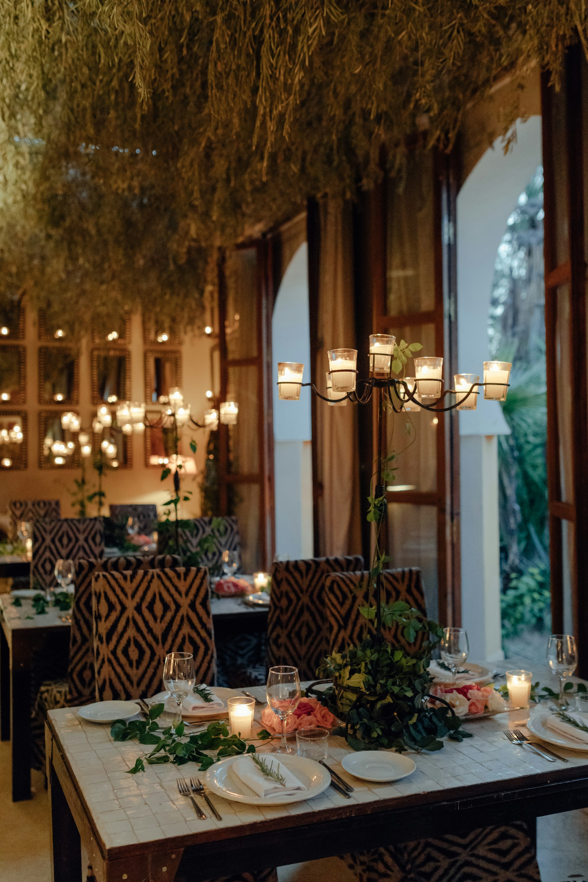 A candlelit table in a warm restaurant dining room, the guest experience a general manager owns